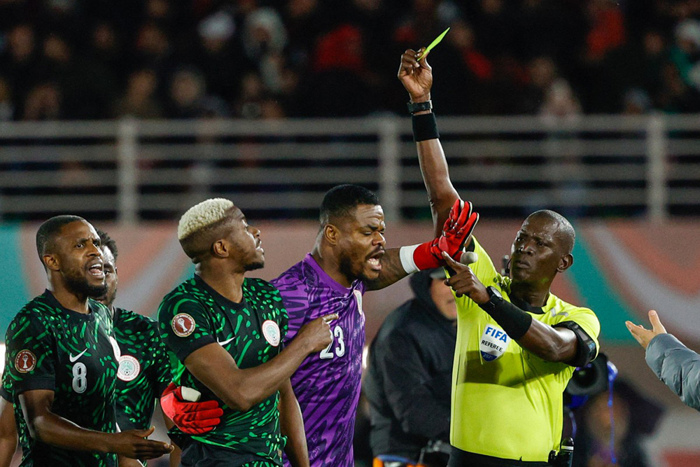 Nigeria's forward #09 Victor Osimhen receives a yellow card from referee Boubou Traore during the Africa Cup of Nations (CAN) Group C football match between Nigeria and Tunisia at Fez Stadium in Fez on December 27, 2025. (Photo by Abdel Majid BZIOUAT / AFP)