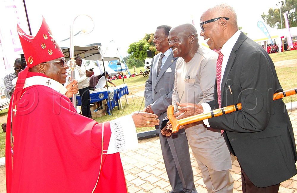 Archbishop Paul Ssemogerere shares a light moment with Gen. Katumba Wamala (centre) as other dignitaries look on. (Photo by Mathias Mazinga)
