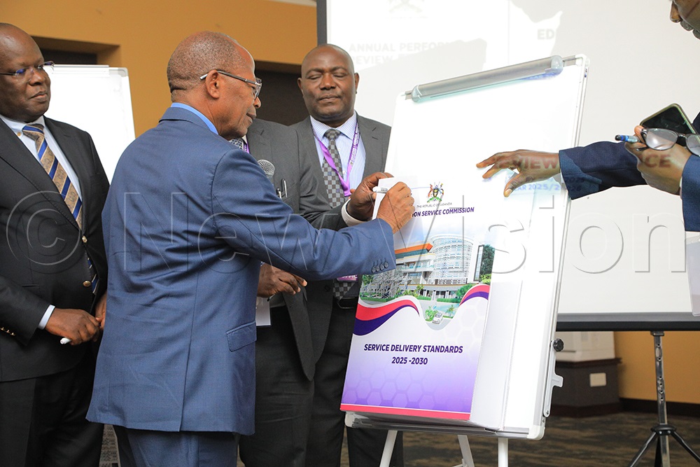 Dr John Chrysostom Muyingo signing on the Education Service Commission on Service Delivery Standards during the Annual Performance Review report on March 30, 2026, at Serena Hotel Kigo in Wakiso. (Photo by David Lukiiza)
