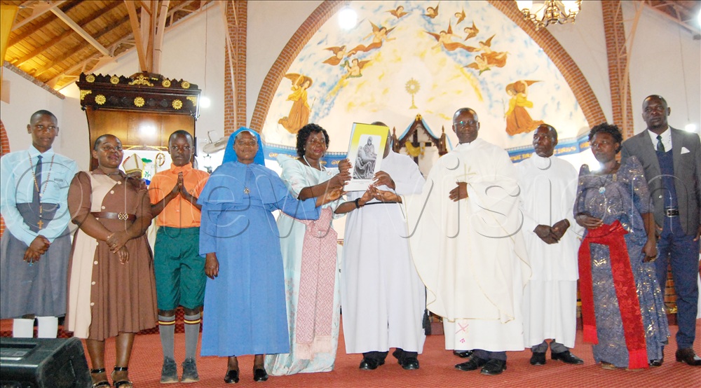 Delegates including; Regina Kitaka (second-left) and Bro. Hillary Kazoora (third-left) exposing the book containing the acts and decrees of the 6th Synod of Masaka Diocese during the launching function at Kitovu Cathedral on Tuesday, September 15, 2026.