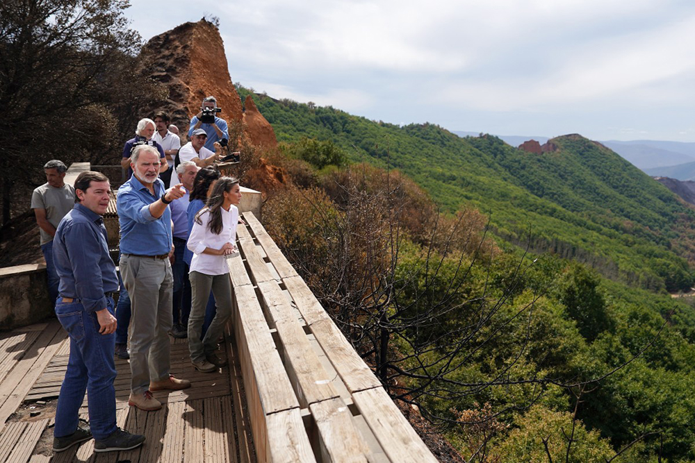 Spain's King Felipe VI (2L) and Queen Letizia speak with Castile and Leon regional president Alfonso Fernando Fernandez Manueco (L) during their visit to Las Medulas, northwestern Spain, in the aftermath of catastrophic forest fires ravaging Spain, on August 27, 2025.