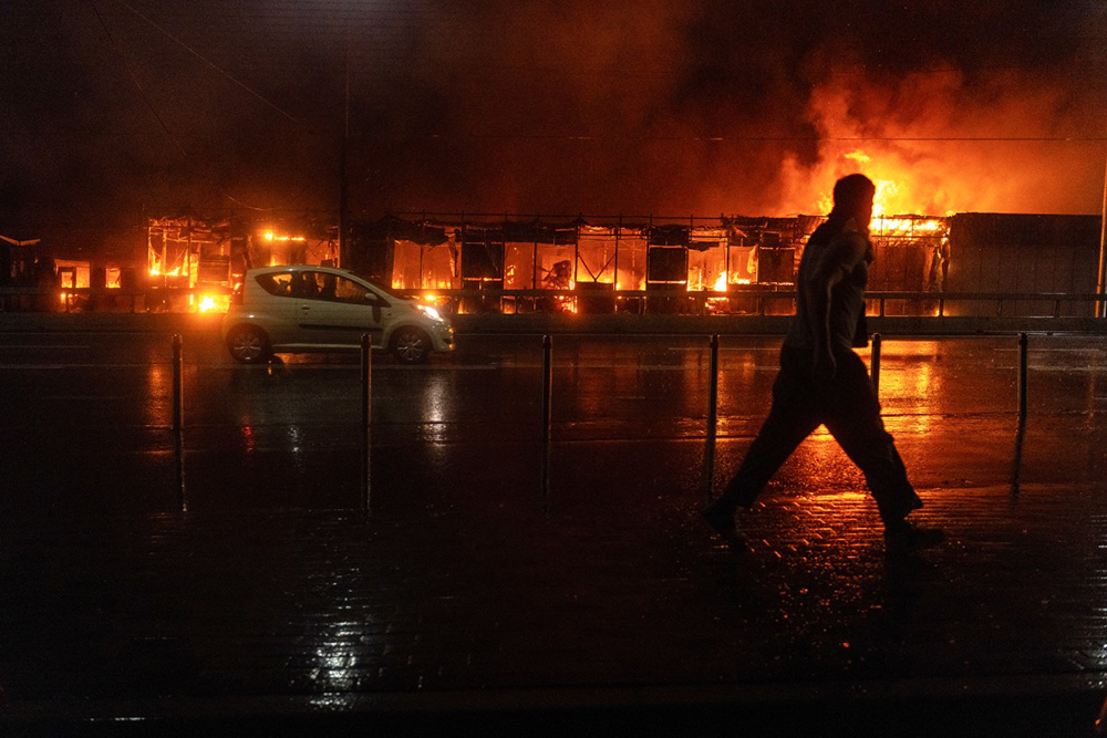 A resident walks in front of a burning market following a Russian missile strike in Kyiv on June 15, 2026, amid the Russian invasion in Ukraine. (AFP)