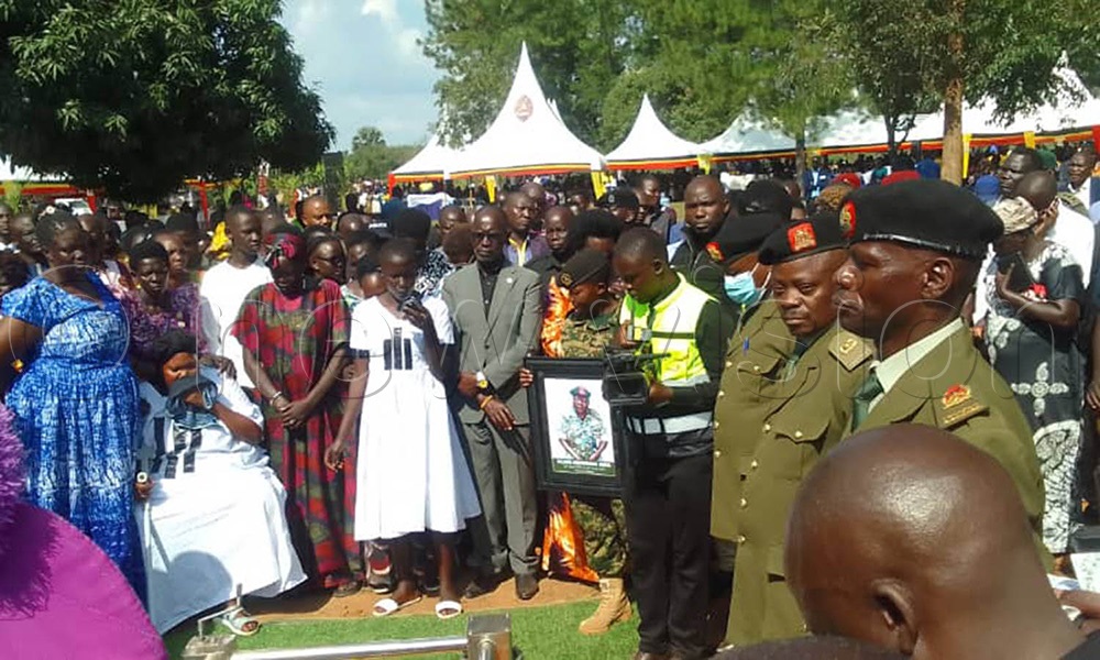 Denis Hamson Obua (C ) with family look on as the body of his brother Major Armstrong Obua is laid to rest. (Photo by Hudson Apunyo)