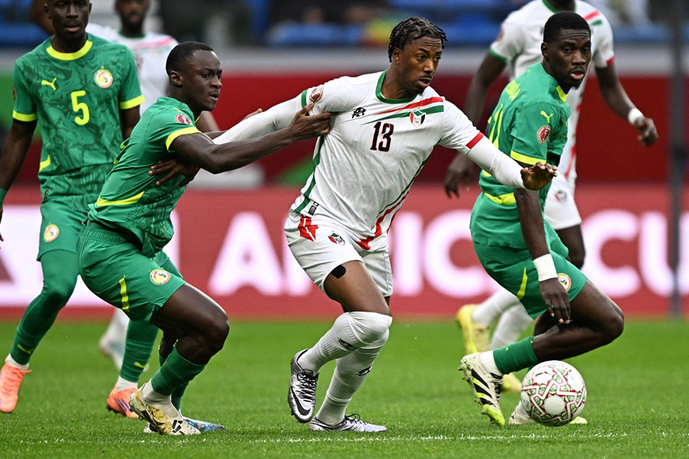Sudan's midfielder #13 Ammar Taifour (C) fights for the ball with Senegal's midfielder #07 Habib Diarra (L) during the Africa Cup of Nations (CAN) round of 16 football match between Senegal and Sudan at Grand Stadium in Tangiers on January 3, 2026. (Photo by Gabriel BOUYS / AFP)