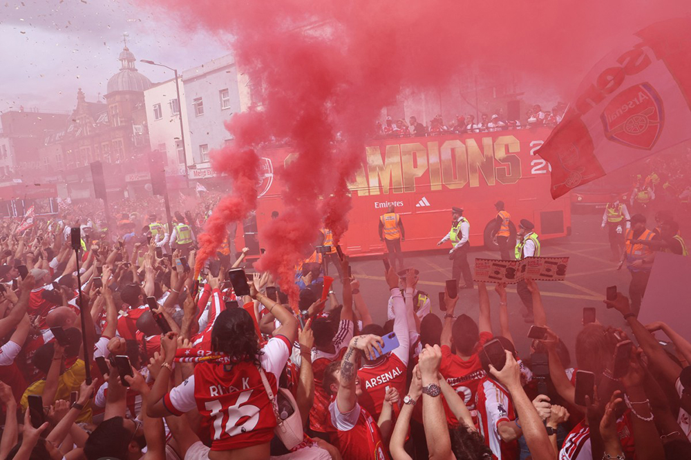 Arsenal supporters cheer their team as it passes during the victory parade for Arsenal's men team's Premier League title victory, around the streets near to the Emirates Stadium, in London, on May 31, 2026. It is the first Premier League title for the North London team since the 2003-04 season