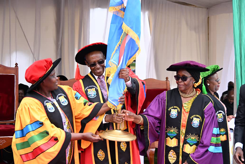 Vice President Jessica Alupo handing over flag to Canon Mathew Rukikaire, the new Kabale University chancellor. (VPPU)
