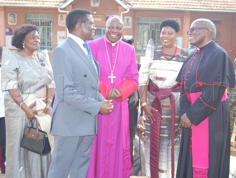 Katikkiro Charles Peter Mayiga (wearing a grey suit) shares a light moment with Bishop Serverus Jjumba (entre) as Msgr. Charles Kasibante (centre), Immaculate Lwanga (second-right) and Margaret Mayiga (left) look on. (Photo by Mathias Mazinga)