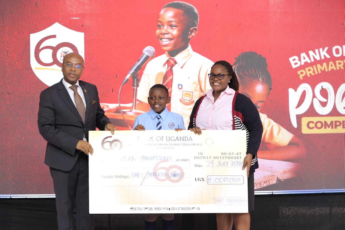Elnathan Tumwebaze from Peak Primary school together with his teacher recieve a dummy check after emerging second runners up.