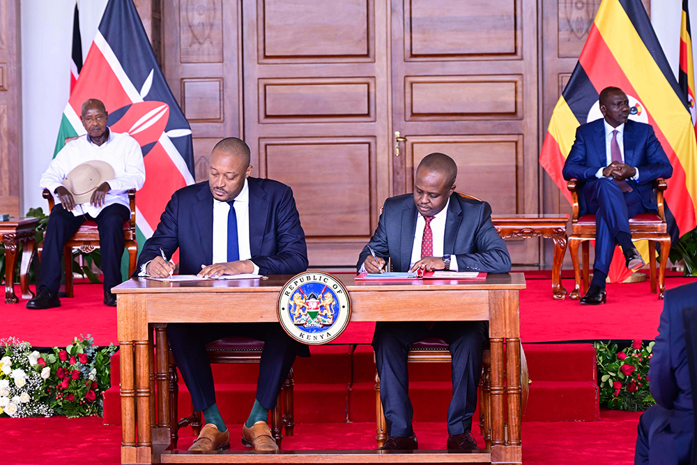 Uganda Investment Authority's Director General, Robert Mukiza, and his Kenyan counterpart signing an MOU on Investment promotions at Nairobi State House on Wednesday as Presidents Museveni (L) and Ruto (R) look on. (PPU)