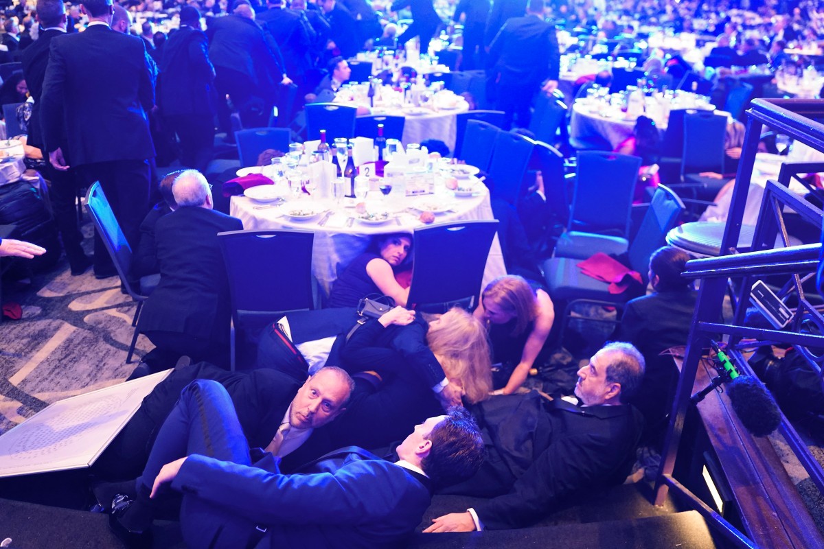 Guests take cover after a un-kown safety event took place as President Donald Trump was to speak to attendees of the annual White House Correspondents Association Dinner. AFP Photo