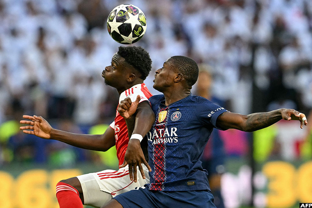 Arsenal's midfielder Bukayo Saka rose to battle for the ball with opponent Nuno Mendes