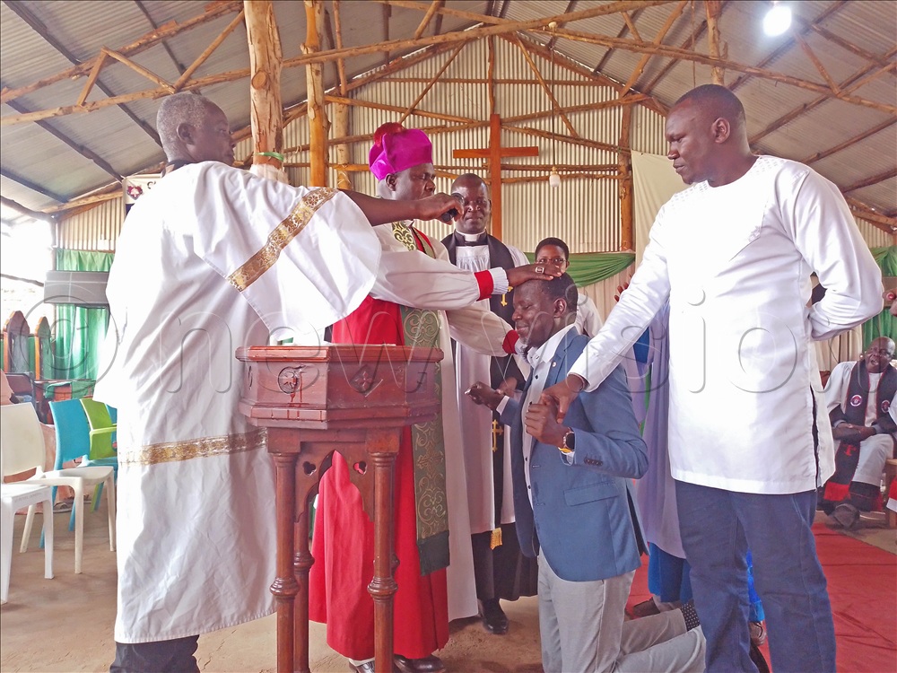 Emmanuel Anguria being baptised by bishop Kosea Odongo on Independence Day at St Peter's Cathedral, Soroti