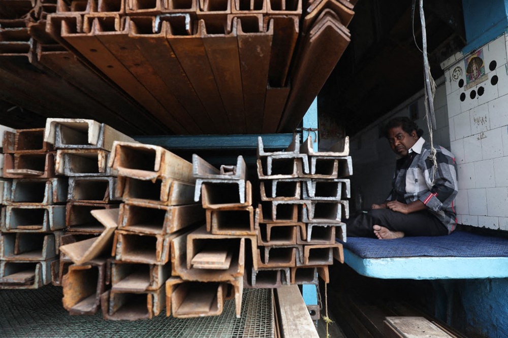 A trader sits inside his shop at a wholesale steel and iron market in Kolkata, India. (AFP)