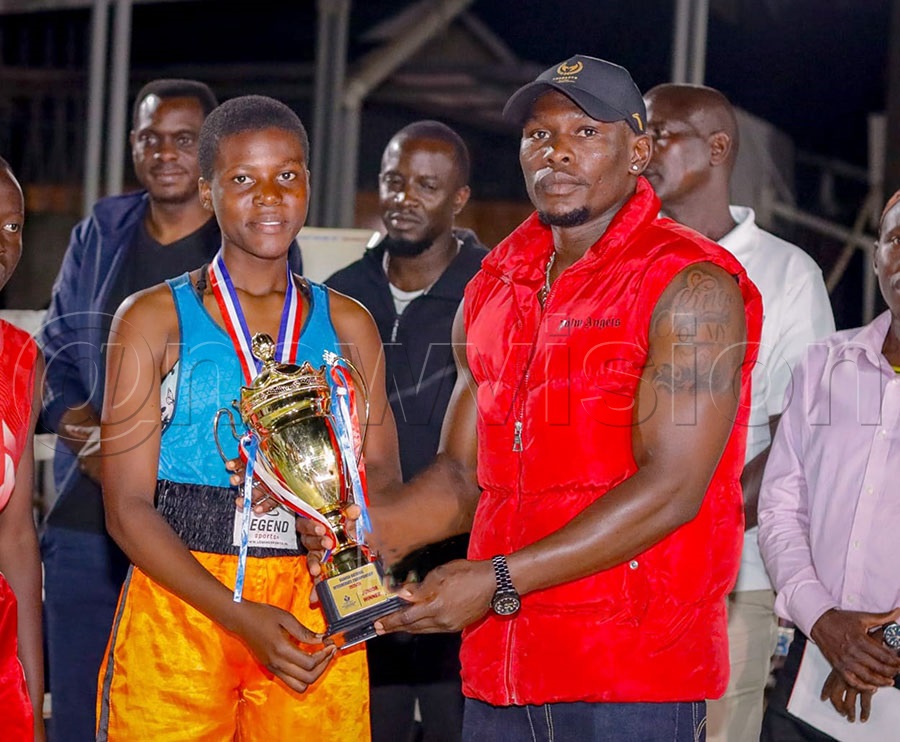 Former national team captain Shadir Musa (right) handing a women's title to one of the Lukanga BC's boxers