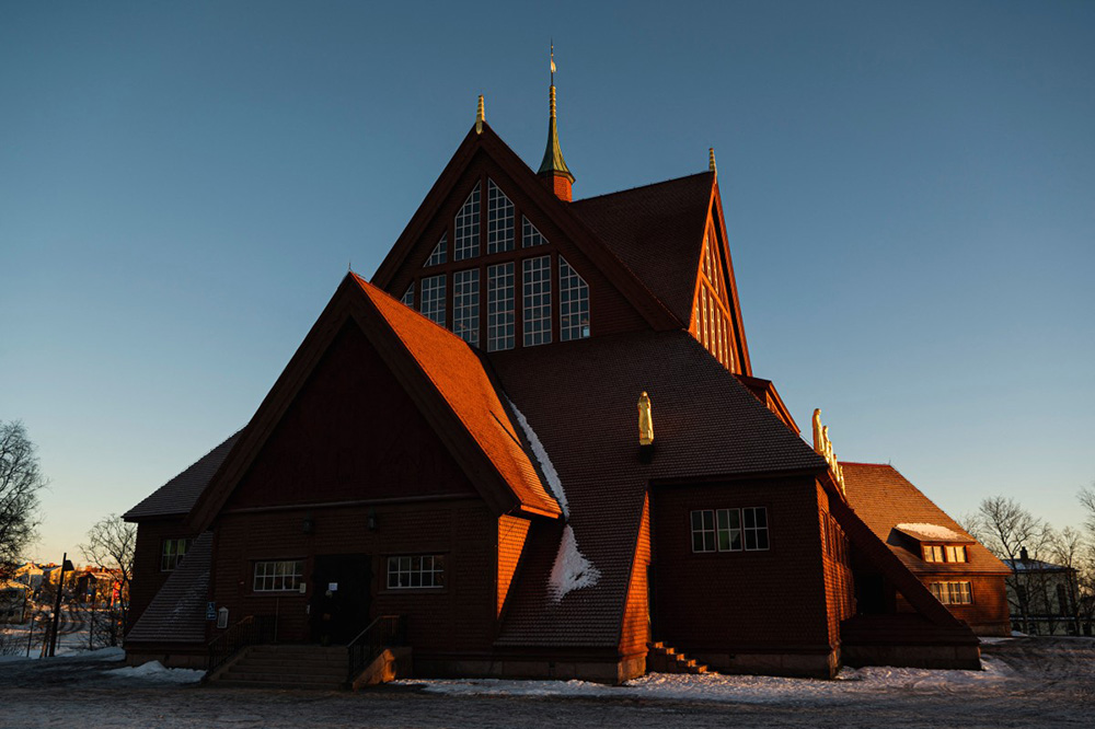 The iconic large red wooden church, considered one of Sweden's most beautiful buildings, is pictured near the old city centre of Sweden's northern town, Kiruna, situated in the northernmost province, Lapland, on November 20, 2022. (Photo by Jonathan NACKSTRAND / AFP)