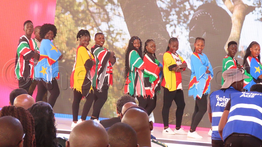 Factory staff crowd the stage for a photo moment with Ceasefire author Gen. Salim Saleh. (Credit: Titus Kakembo)  