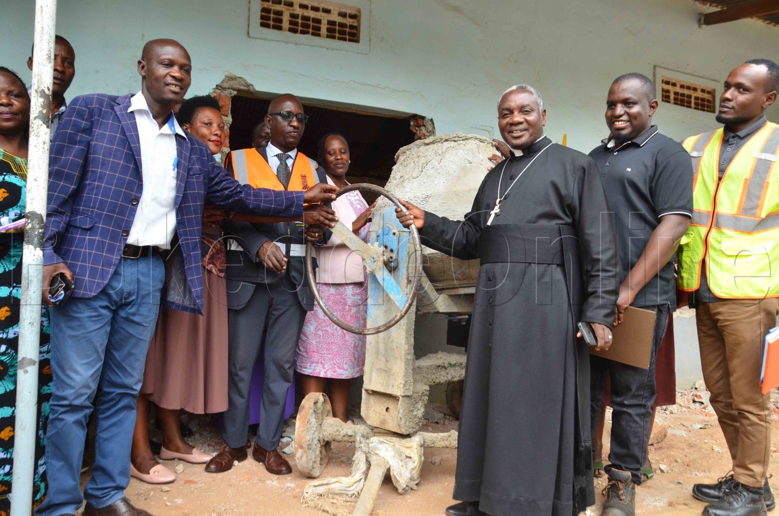 Ab'ebyenjigiriza nabalala nga batongoza okuddabiriza ebizimbe. Baabadde ku ssomero lya Masuliita S.S
