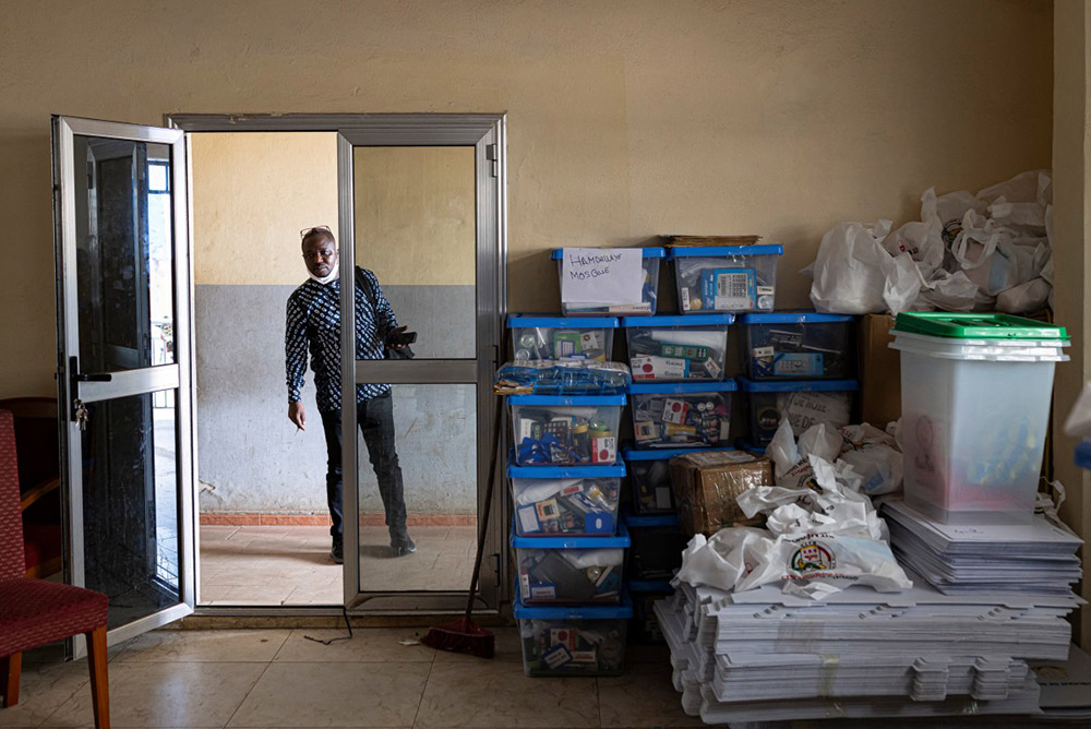 A man looks inside a room containing ballot boxes and electoral materials at Ratoma's City Hall in Conakry, on September 20, 2025, ahead of the constitutional referendum on September 21, 2025. (Photo by PATRICK MEINHARDT / AFP)