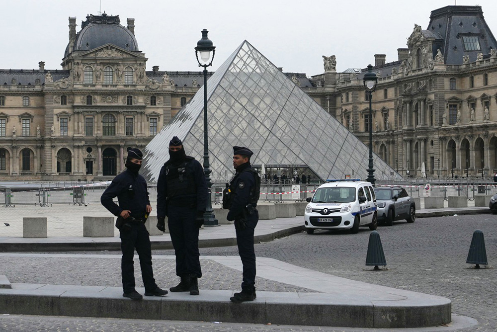 French police officers stand in front of the Louvre Museum after robbery, in Paris on October 19, 2025. Robbers broke in to the Louvre and fled with jewellery on October 19, 2025 morning, a source close to the case said, adding that its value was still being evaluated. (Photo by Dimitar DILKOFF / AFP)