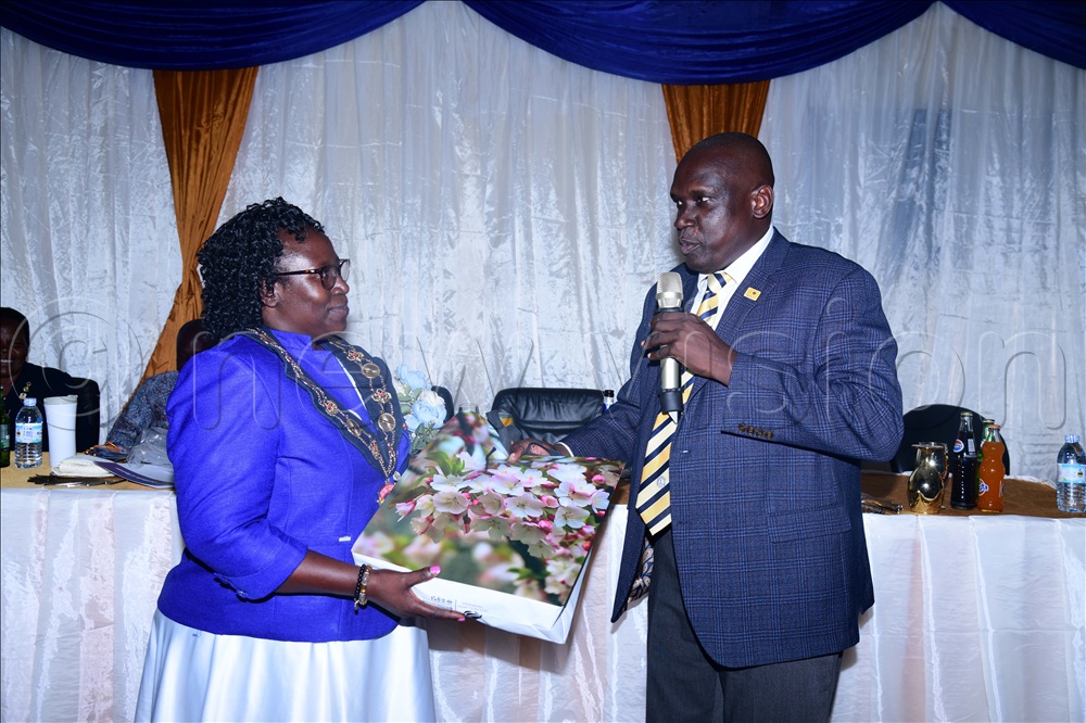 Johnson Opolot, the Lions Club president of Kumi central rewarding the governor of district 411B, Tush Naturinda.