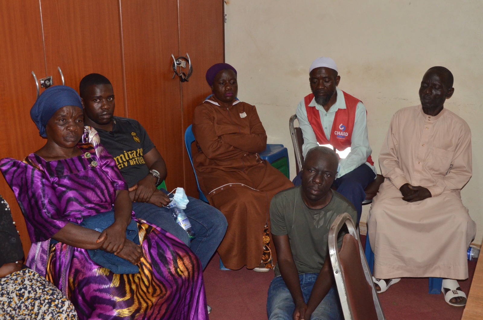 Abamu ku ba ffamire erumiriza Noordin Ssewanyana (atudde wansi) okubatulugunya ku ttaka nga bali mu ofiisi ya Gen. Lukyamuzi