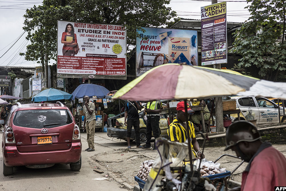 A billboard advertising studies abroad is seen among other billboards in Douala, on October 7, 2025