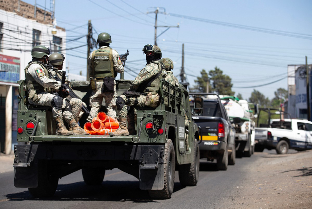 Members of the Mexican Army patrol the Morelia–Patzcuaro Highway to prevent vehicle fires and road blockades in Michoacan state, Mexico, on February 23, 2026. Mexico has deployed 10,000 troops to quell clashes sparked by the killing of the country's most wanted drug lord, which have left dozens dead, officials said on February 23. (Credit: AFP)