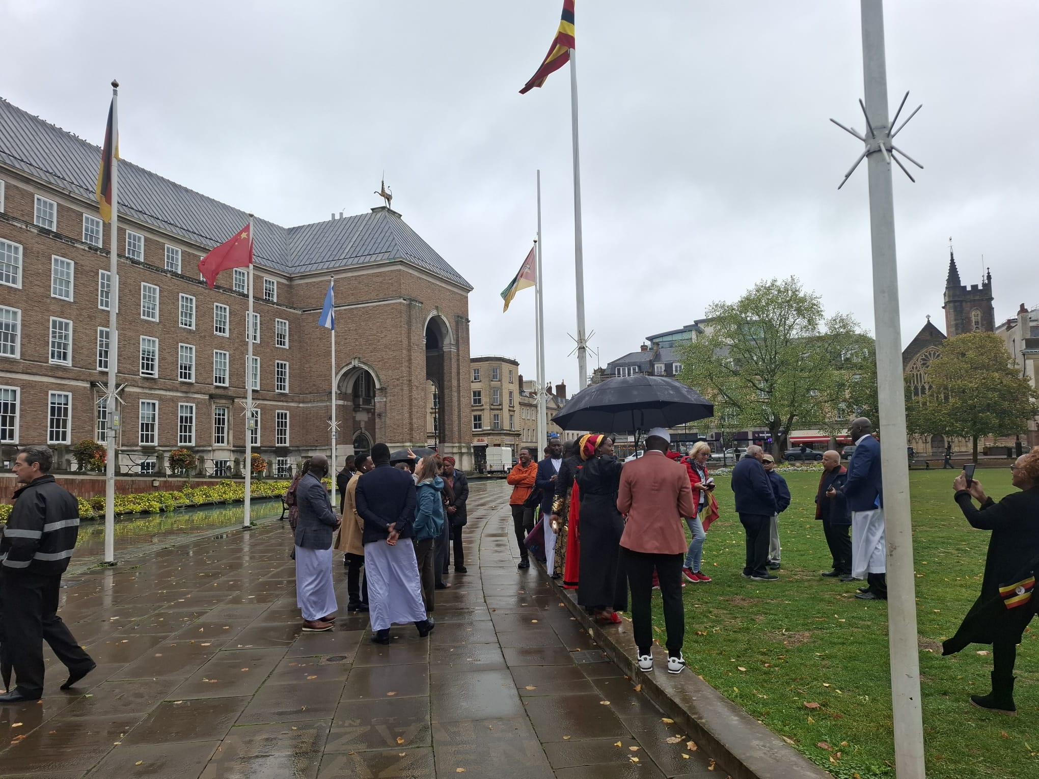 Members of the Ugandan community in southwest of England chatting hoisting their flag.