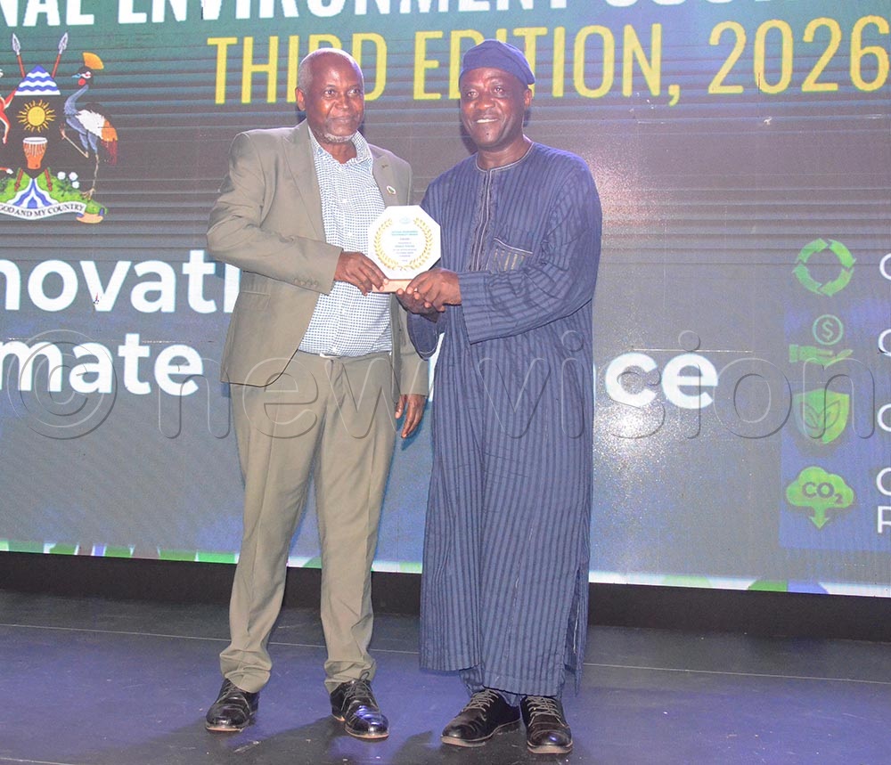 Executive Director Pio Vision Africa, Geoffrey Kamese handing over the NEMA award to Vision Group Multimedia Journalist Gerald Tenywa during the event at Serena Hotel on Friday June 19. (Credit: Isaac Nuwagaba)