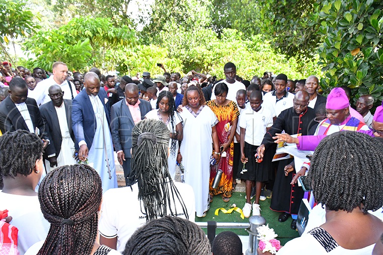 Herbert Kyeyamwa (left) and Busoga Kingdom's Prime Minister Dr Joseph Muvawala (2nd left) look on as the casket containing the body of the late Mzee William Kyeyamwa was being lowered into the grave by A-Plus funeral services at Bulalu village in Bukanga sub-county in Luuka district on August 28, 2025.   Photo by Donald Kiirya. (Photo by Donald Kiirya)