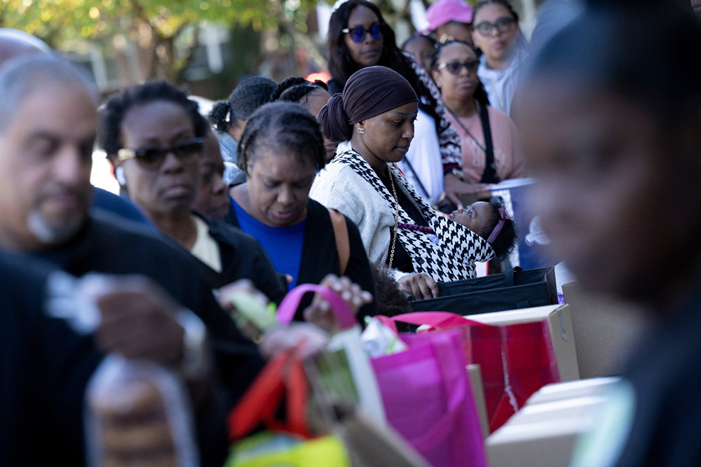 People receive food for furloughed federal workers at No Limits Outreach Ministries oln October 21, 2025 in Hyattsville, Maryland.
