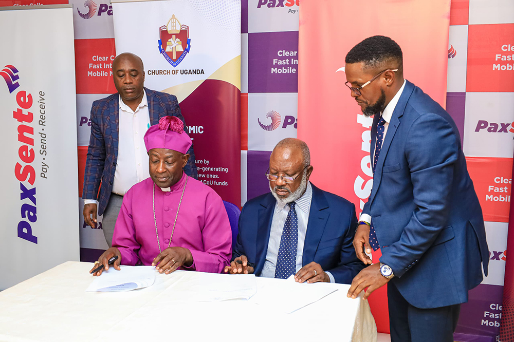 Archbishop of the Church of Uganda, Rt Rev. Dr Stephen Kaziimba Mugalu signing the MoU with John Kamya Mukalazi, the chairman of Hamilton Telecom and Paxtel Mobile. (Courtesy)
