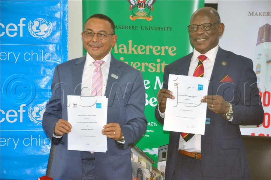 Prof. Nawangwe (Right) and Dr. Nandy display the agreement they signed aimed at improving the lives and rights of children in Uganda. The function took place at Makerere University. (Credit: John Odyek)