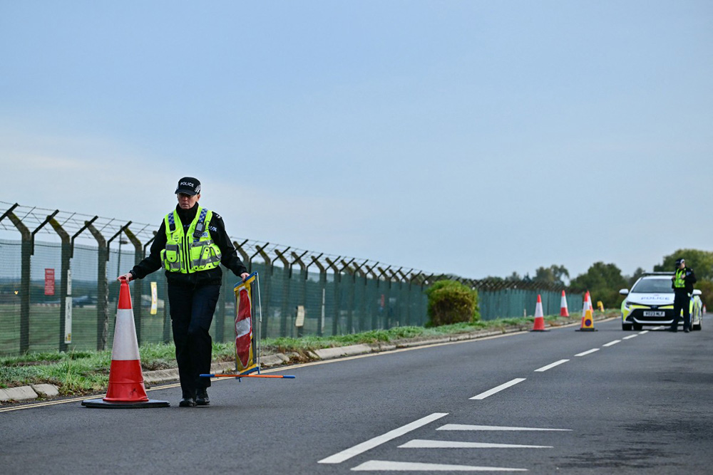 Police continue to man a roadblock outside RAF Fairford base (L) in Fairford, south-west England on September 28, 2026, a day after British counter-terrorism police were probing "a major" incident near the base used by the US Air Force. (Photo by Ben STANSALL / AFP)