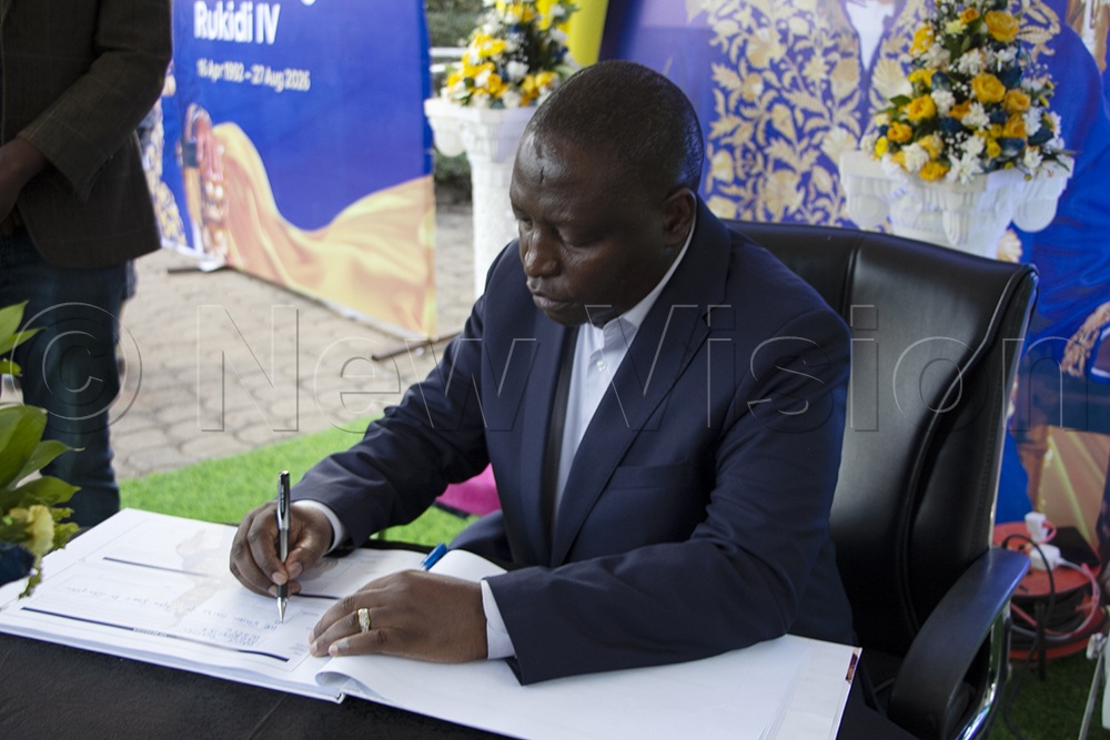 Minister David Bahati signs the condolence book as he mourns King Oyo Nyimba Kabamba Iguru. (Credit: Nickson Turyahikayo)