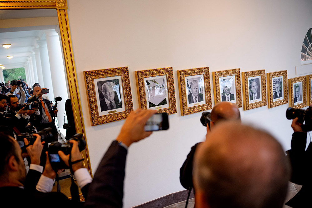 Members of the media take photographs of framed portraits of U.S. President Donald Trump flanking an image of former U.S. President Joe Biden's signature and an autopen along "The Presidential Walk of Fame" on the wall of the colonnade outside of the Oval Office as Trump meets with President of Turkey Recep Tayyip Erdogan at the White House on September 25, 2025 in Washington, DC.