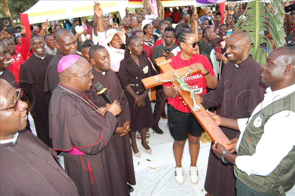 Catholic youth chaplains and youth leaders look on as Archbishop Paul Ssemogerere (wearing a skull-cap)  performs the symbolic handing over of the crucifix to Fr. George  William Ssentamu (second-right) and other youth leaders from Entebbe Vicariate,  who are the organisers-designate of next year's Kampala Archdiocese international Youth Day celebration. This was during the celebration of the Kampala Archdiocese International Youth Day at Gayaaza Catholic parish on Saturday, November 22, 2025. 