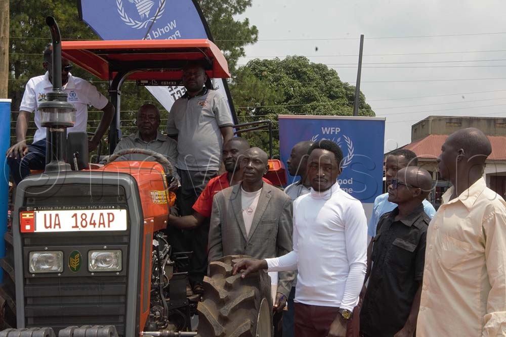 The leaders of farmers, led by Josephat Friday, the chairperson of the cooperative receive the tractor from Ripple Effect officials. (Credit: Peter Abaanabasazi)