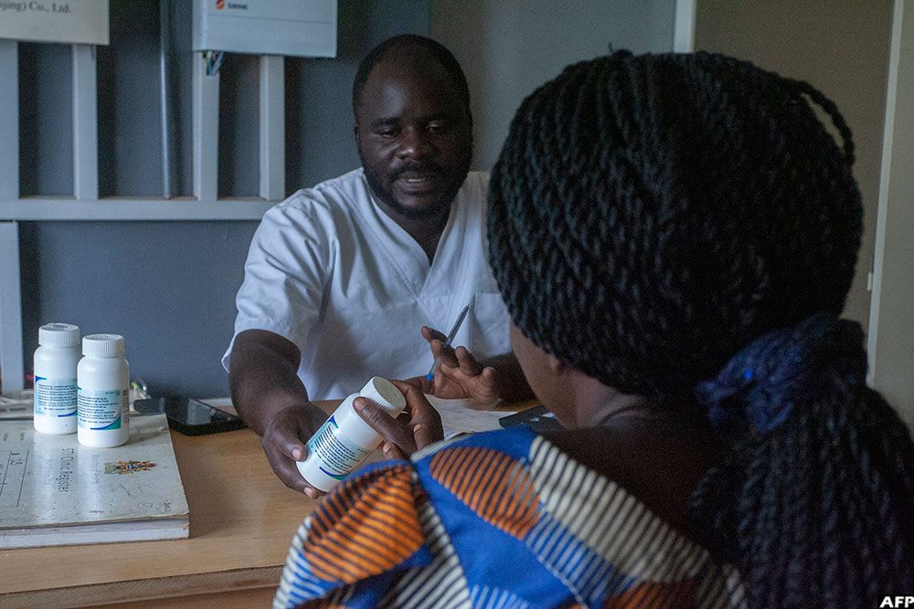 Dr George Dulani presents a bottle of antiretrovirals (ARVs) to a patient at the Mphetsankhuli outreach clinic in Lilongwe on January 19, 2026.