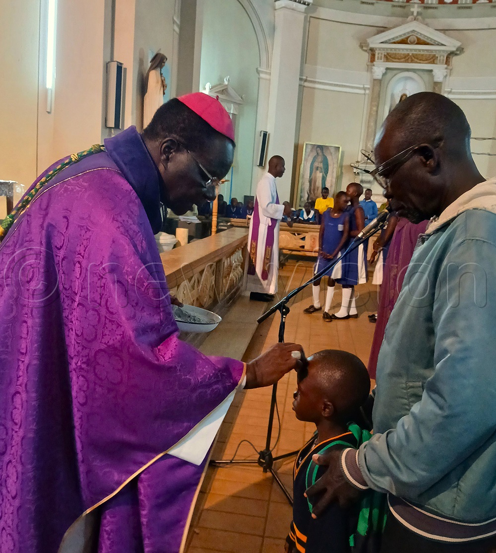 Raphael P&rsquo;Mony Wokorach, Archbishop of Gulu Archdiocese putting ash on the forehead of a young christian at St Joseph's Cathederal in Gulu city. (Photo by Claude Omona)
