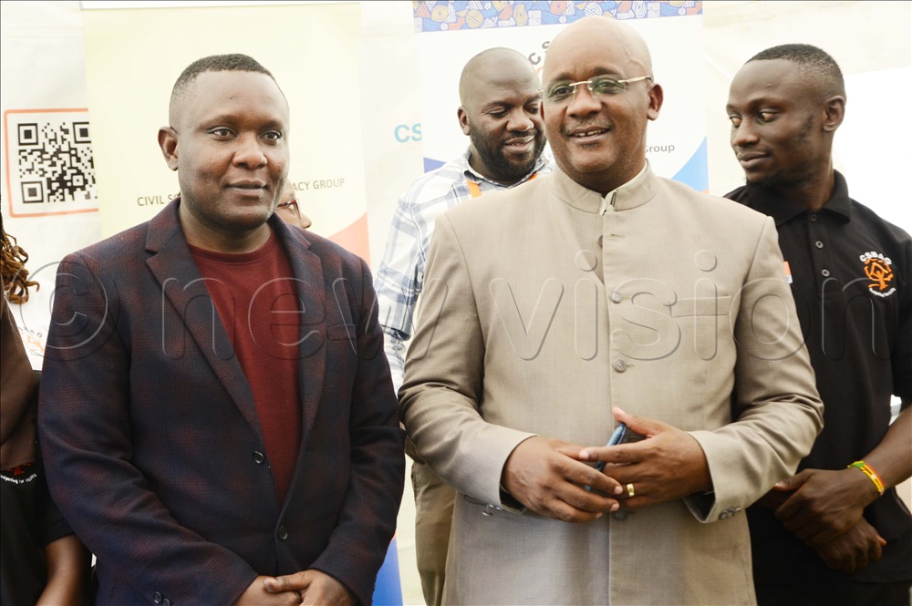 Moses Mulondo, the New Vision deputy business editor interacts with Julius Mukunda, the CSBAG executive director as other CSBAG staff look on during a press conference at Civil Society Budget Advocacy Group in Ntinda on November, 12 2025.