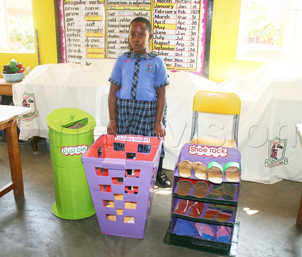 A pupil displays some of the items they made out of waste. (Photo by Maureen Nakatudde)