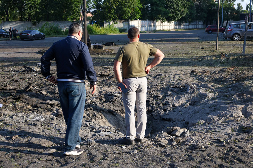 Local residents examine a crater outside a residential building damaged after a Russian missile strike in Kyiv on July 19, 2026, amid the Russian invasion of Ukraine. (Photo by Serhii Okunev / AFP)