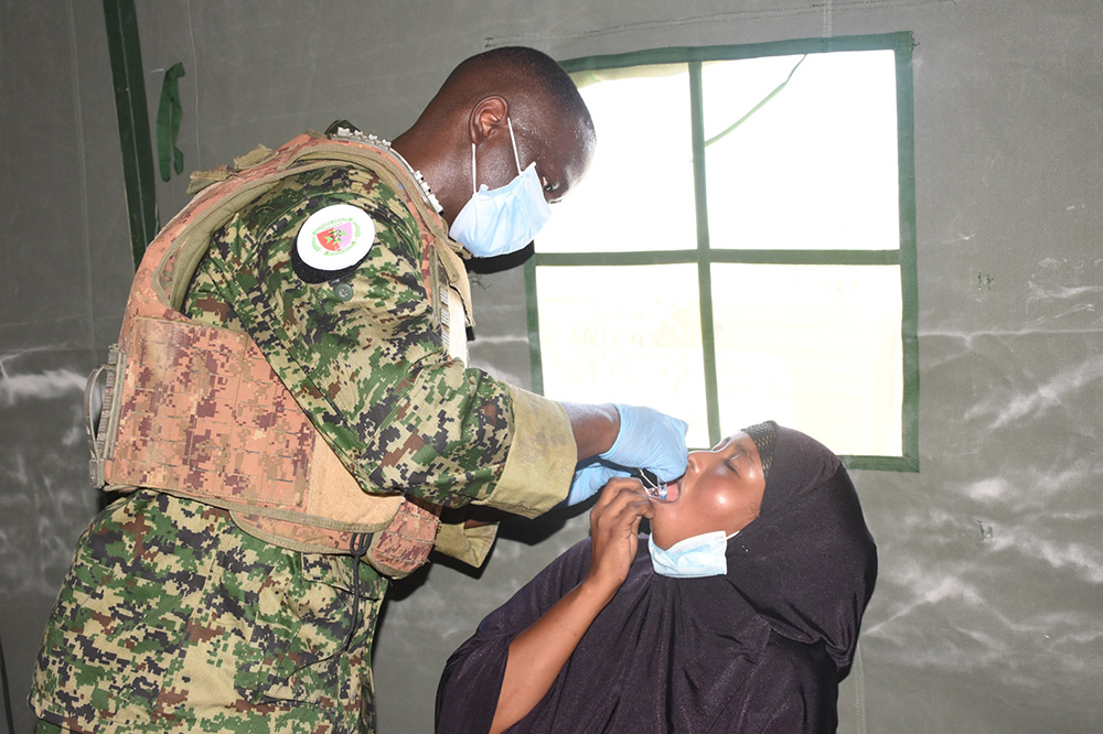 A UPDF dentist doing dental care on a patient. (Credit: UPDF)