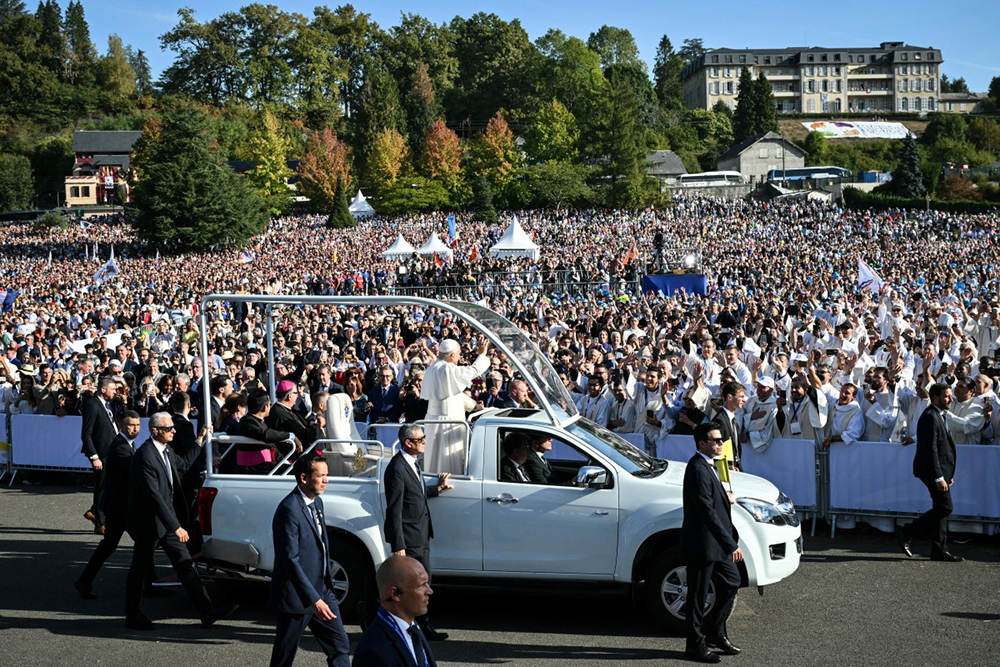 Pope Leo XIV waves to worshippers as he arrives on board of the Papamobile (popemobile) to celebrate a holy mass at the Prairie of the Shrine of Our Lady of Lourdes, southwestern France, on September 27, 2026 on the third day of his visit to France.