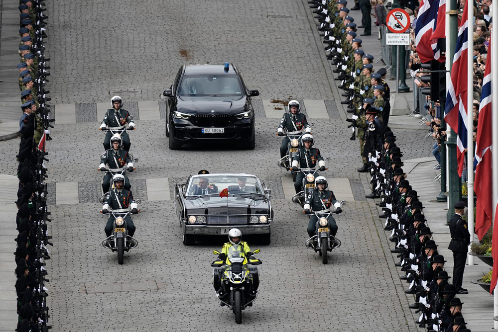 Honour guards stand on both sides of the street as King Haakon VIII of Norway arrives in a car (front) for the oath-taking ceremony in the Storting's main chamber (Norway's Parliament) in Oslo on September 1, 2026. AFP