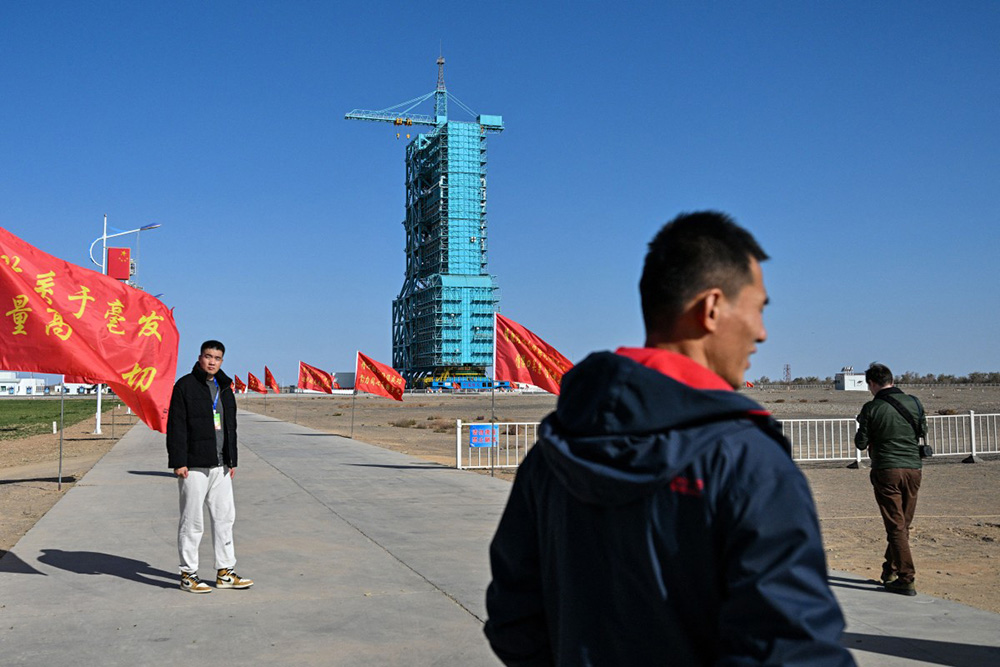 The Long March-2F carrier rocket, carrying the Shenzhou-21 spaceship, is seen encased in blue scaffolding on the launch pad a day before the mission's launch at the Jiuquan Satellite Launch Centre in the Gobi desert in northwest China on October 30, 2025. (Photo by Hector RETAMAL / AFP)