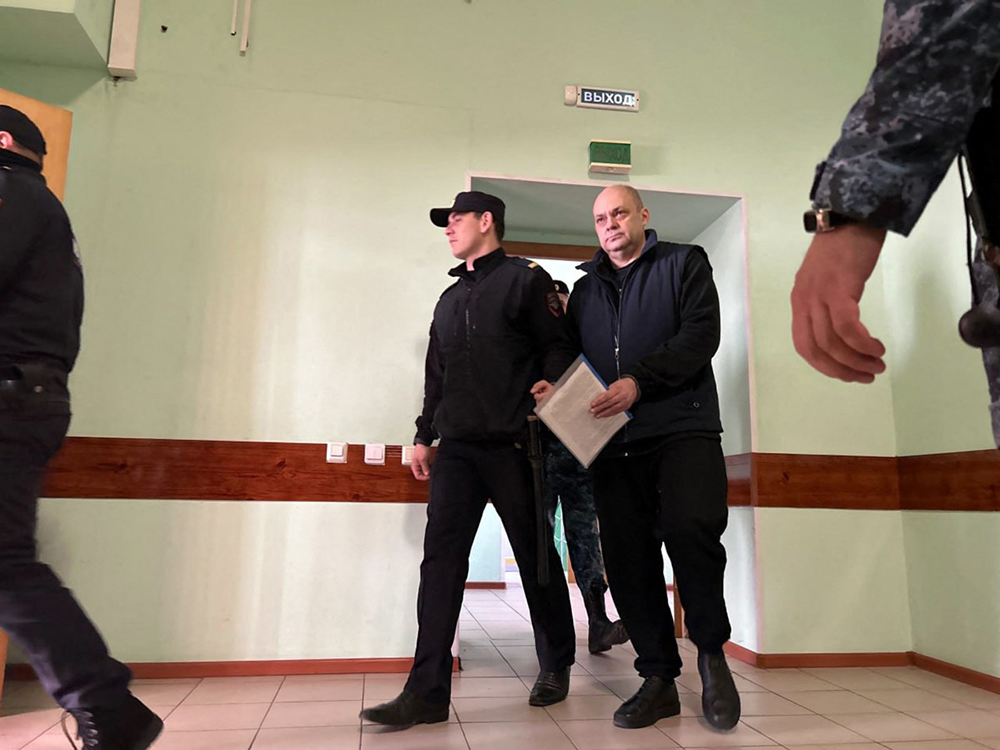 In this handout photograph taken and released by the Lininsky District Court of the city of Kursk press service on April 2, 2026, former governor of Russia's Kursk region Alexei Smirnov, who was arrested along with his ex-deputy on suspicion of embezzling over 12 million USD of funds earmarked for border defences with Ukraine, is escorted for a hearing in Kursk April 2, 2026. 
