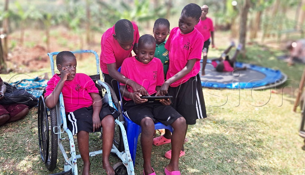Children try using their new tablets during the event. (Credit: Maureen Nakatudde)
