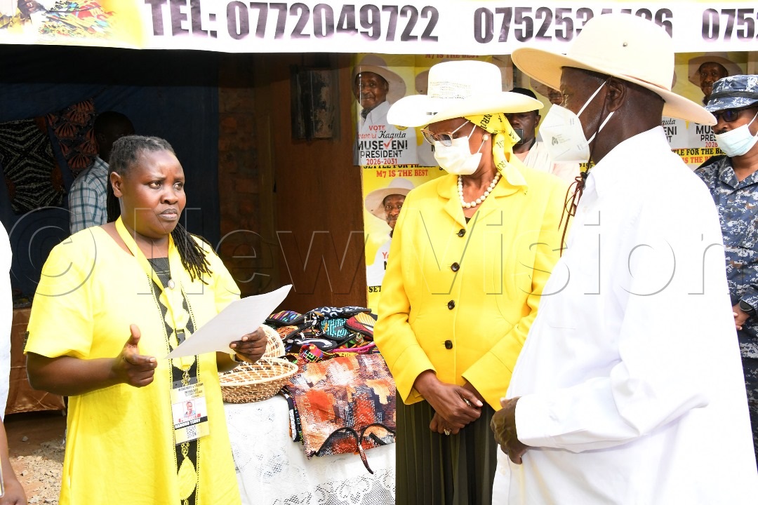 President Museveni together with the First Lady and Minister for Education and Sports, Janet Museveni (right), listening to Teddy Akankunda, Treasurer of Mutungo, Mbuya I & II Tailors Emyooga Sacco.